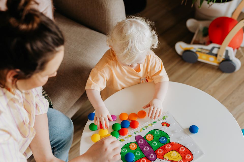 Woman playing with child at table